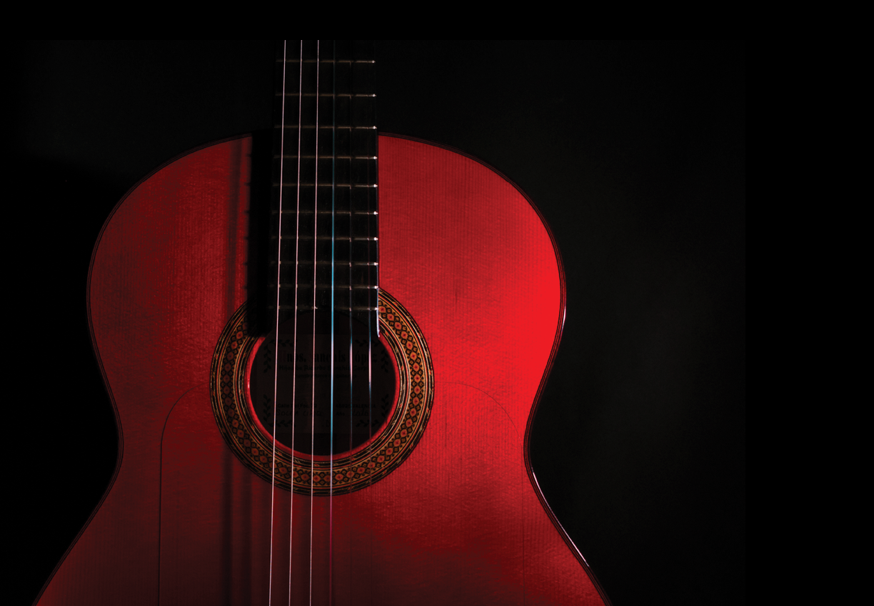 spanish classical red guitar close-up on a black background