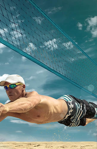Beach volleyball player in action at sunny day under blue sky.