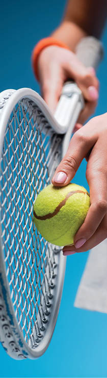 cropped view of sportive young woman holding tennis racket and ball while playing on blue