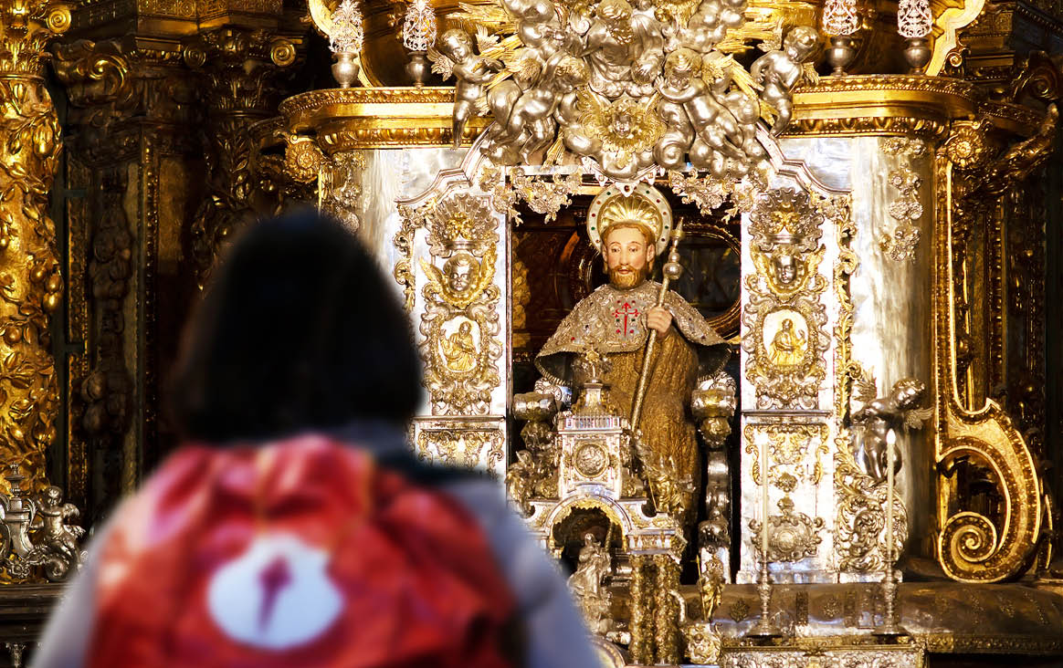 pilgrim woman unfocused in Santiago of Compostela altar cathedral after finishing the way of st James  , Galicia, Spain