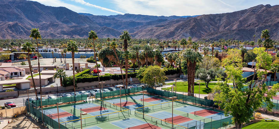 Aerial view of pickleball courts at Rancho Mirage Community Park with palm trees and beautiful mountains in the distance in the Palm Springs area of California.