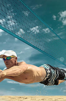 Beach volleyball player in action at sunny day under blue sky.