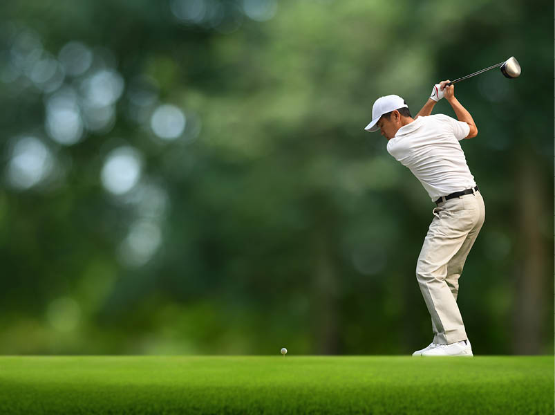 Front view of Golfer driver back swing before hitting golf ball down the fairway.