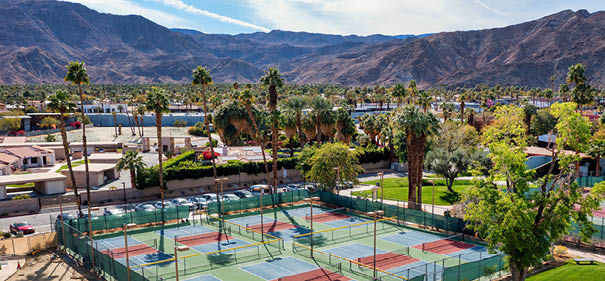 Aerial view of pickleball courts at Rancho Mirage Community Park with palm trees and beautiful mountains in the distance in the Palm Springs area of California.
