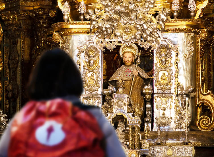 pilgrim woman unfocused in Santiago of Compostela altar cathedral after finishing the way of st James  , Galicia, Spain