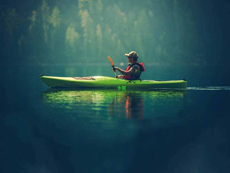 Kayak Tour on the Lake. Middle Age Caucasian Men in the Kayak on the Scenic Lake.