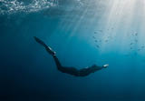 September 10, 2020. Anapa, Russia. Professional freediver in wetsuit with mono fin underwater in transparent sea. Freediving in Black sea