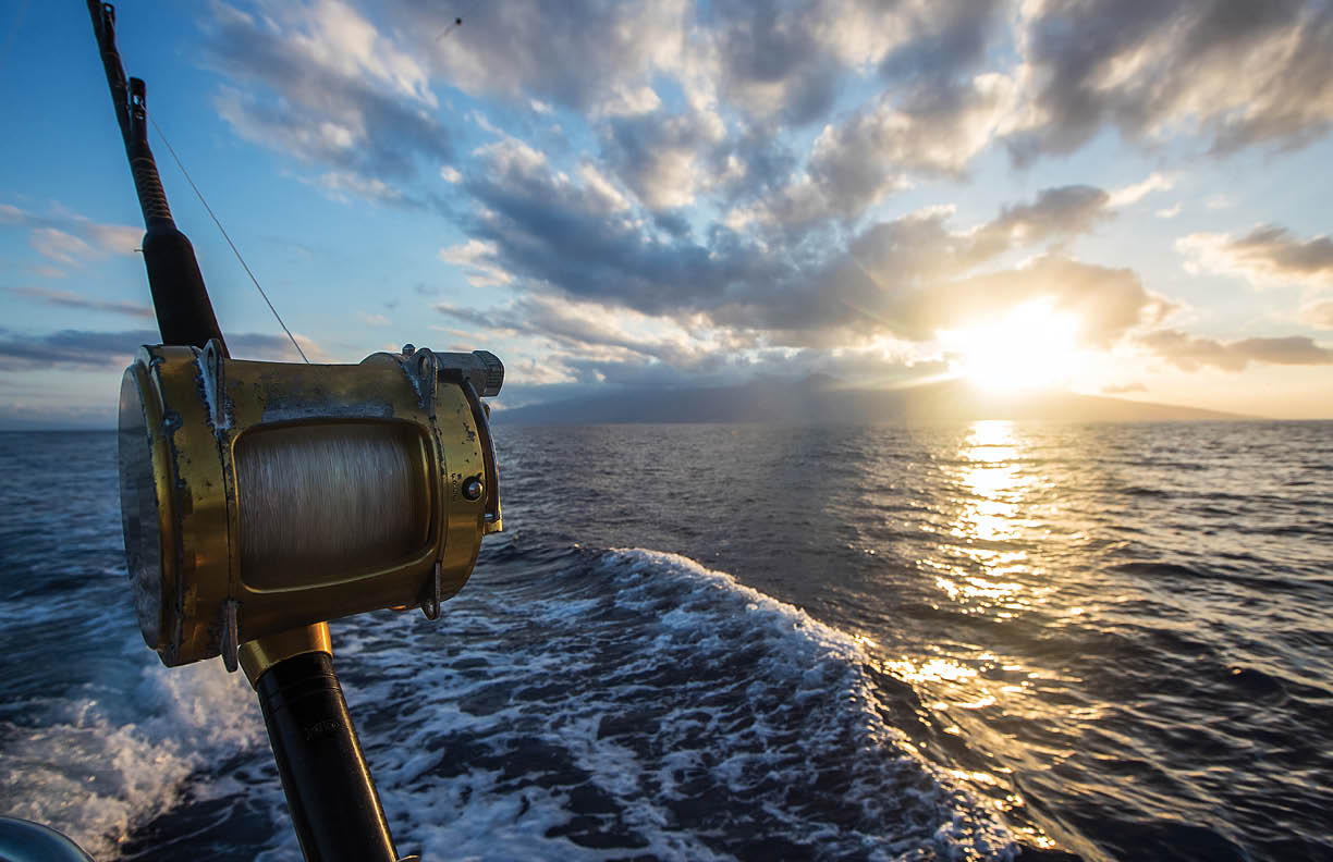 Deep Sea Fishing Reel on a boat during sunrise 