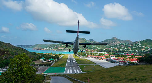 ST. BARTS, FRENCH WEST INDIES - FEBRUARY 4, 2021: Plane landing at Remy de Haenen Airport also known as Saint Barthelemy Airport. At 2,133 ft its runway is one of the shortest in the world