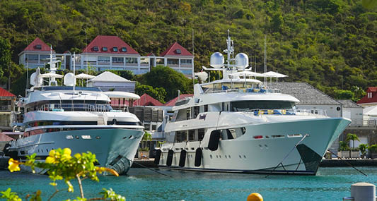 ST BARTS, FRENCH WEST INDIES - FEBRUARY 5, 2021: Mega yachts anchored in Gustavia harbor. It is the capital of Saint Barthelemy, a French-speaking Caribbean island commonly known as St. Barts