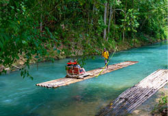 Falmouth, Jamaica - July 07 2019: Martha Brae River, Jamaica. Tourists on bamboo raft rides. Relaxing scenic tour in countryside landscape under canopy trees. People enjoy summer vacation activity.