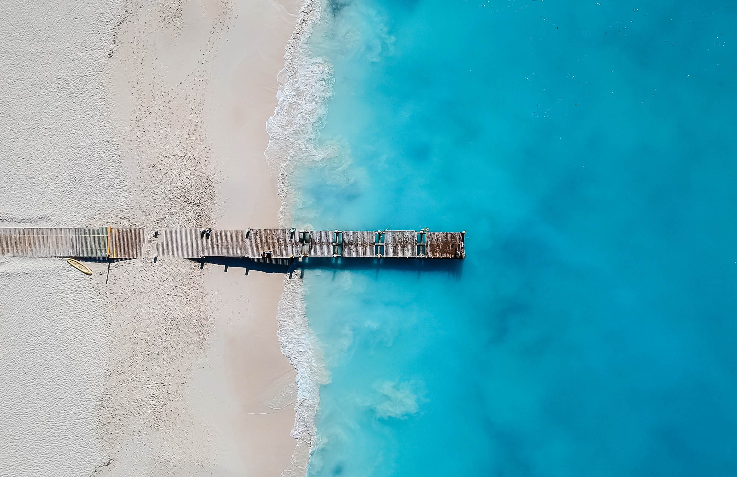 Drone photo of pier in Grace Bay, Providenciales, Turks and Caicos. The caribbean blue sea and white sandy beaches can be seen