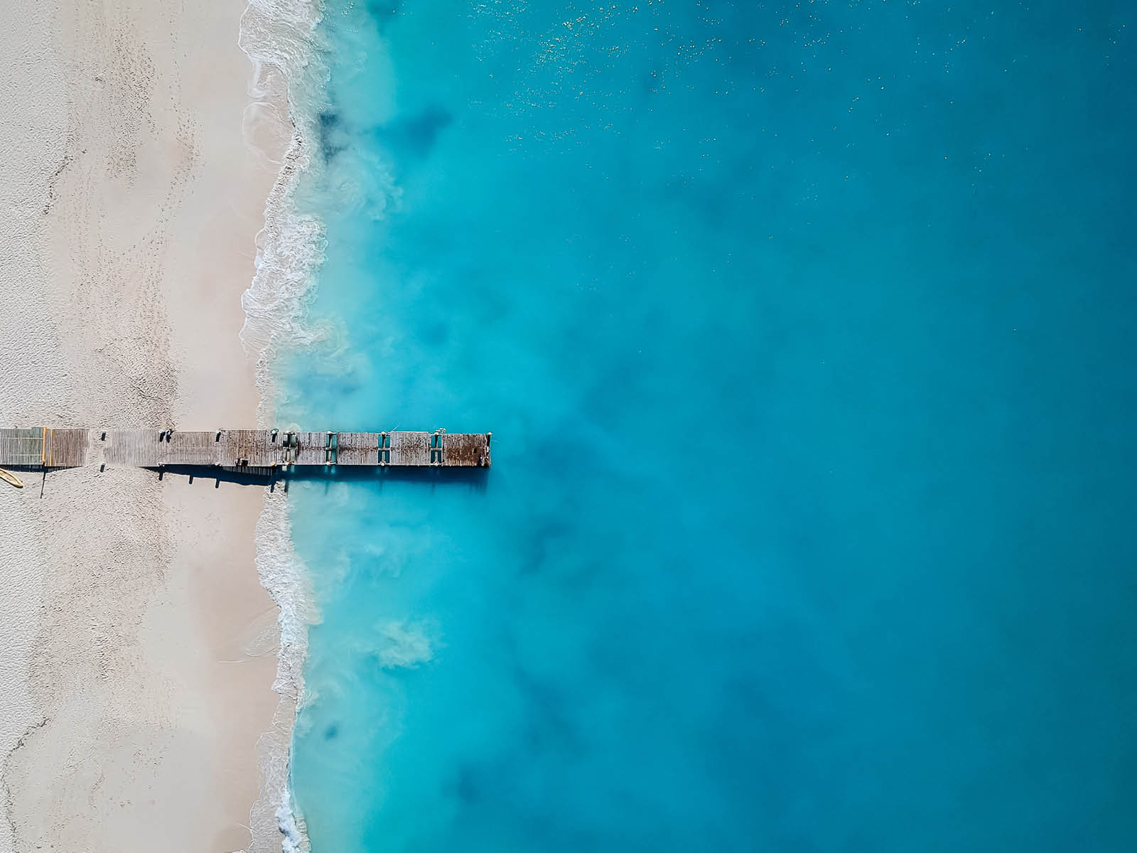 Drone photo of pier in Grace Bay, Providenciales, Turks and Caicos. The caribbean blue sea and white sandy beaches can be seen