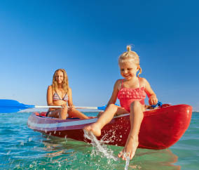 Happy family - young mother, children have fun on boat walk. Woman and child paddling on kayak. Travel lifestyle, parents with kids recreational activity, watersports on summer sea beach vacation.