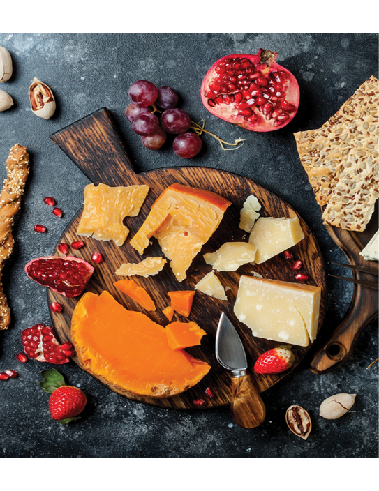 Cheese variety board or platter with cheese assortment, grapes, honey, nuts. Black stone background. Top view, flat lay
