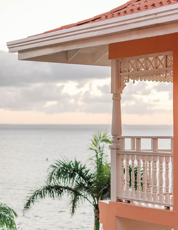 Sunset view from pink balcony: ocean, palms, serene beauty