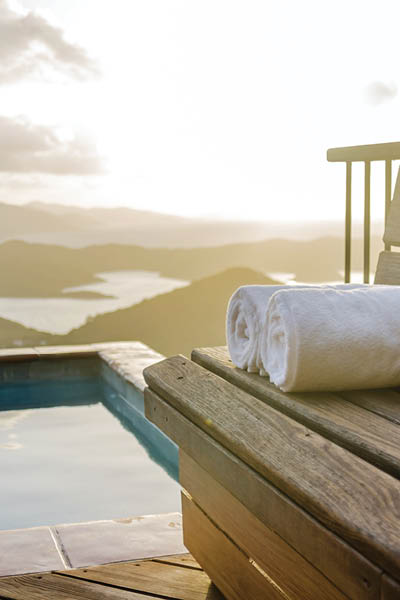 White towels rolled on a wooden bench overlooking the Caribbean Sea