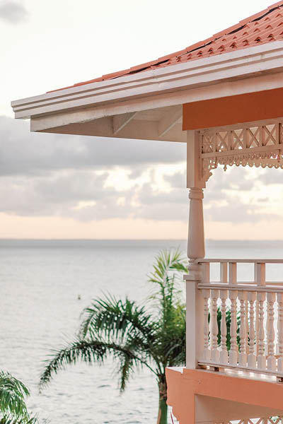 Sunset view from pink balcony: ocean, palms, serene beauty
