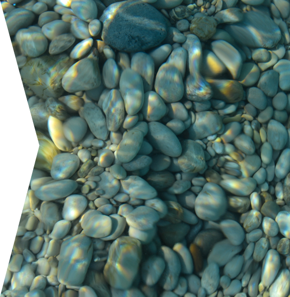 Beautiful colorful pebbles and big stone under turquoise blue clear water, scenic marine background or texture, top view