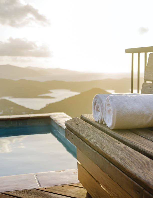 White towels rolled on a wooden bench overlooking the Caribbean Sea