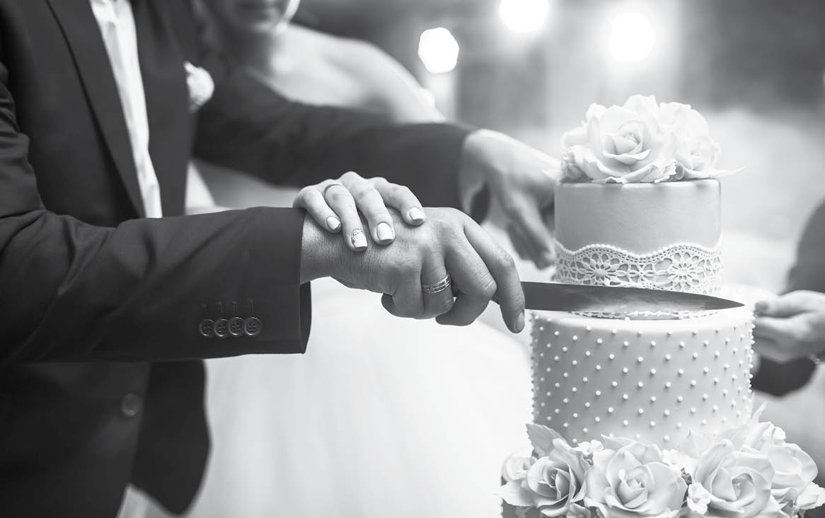 A bride and a groom is cutting their wedding cake. beautiful cake. nicel light. wedding concept