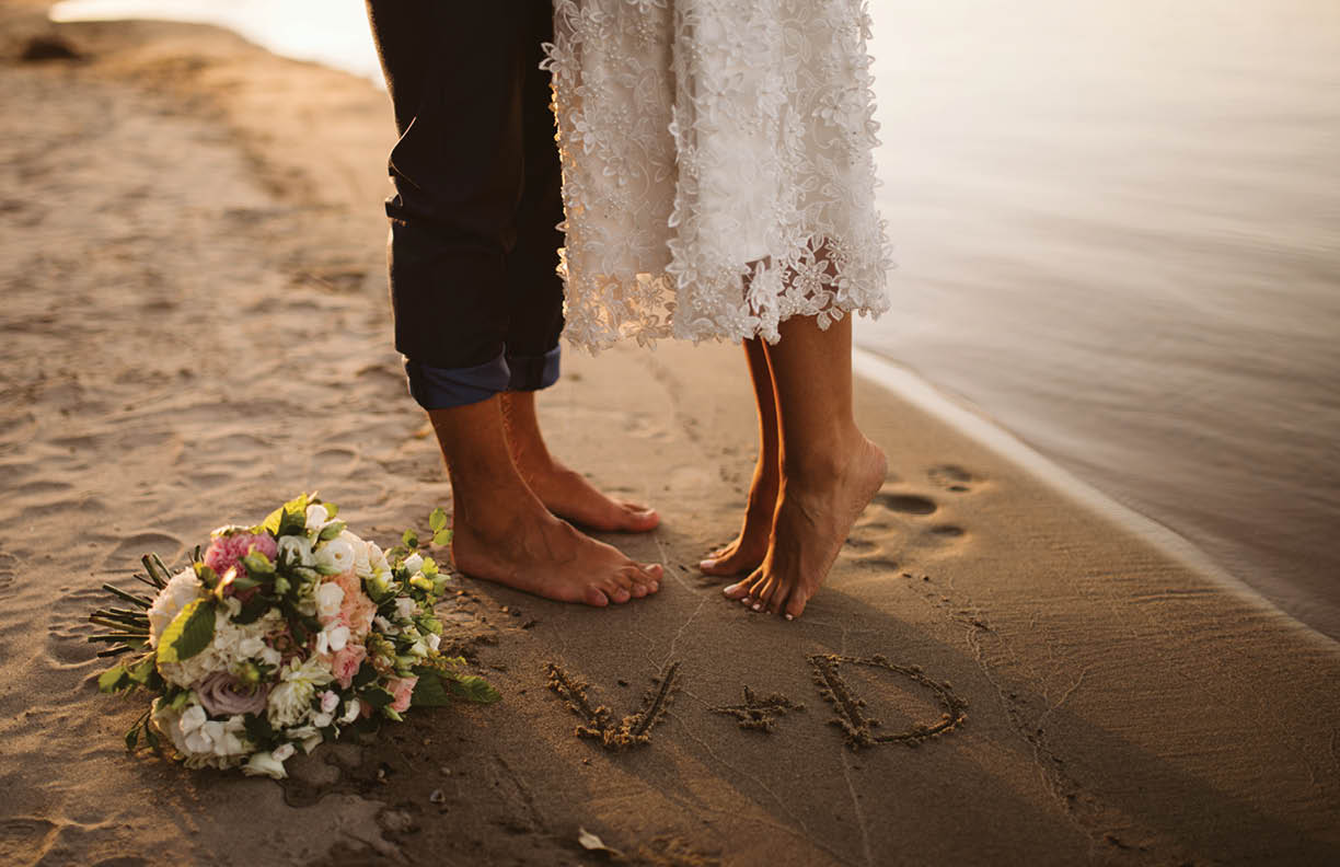 The bride's and the groom's feet in the sand on the beach