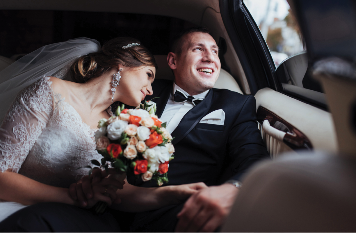 young couple in a car in wedding day