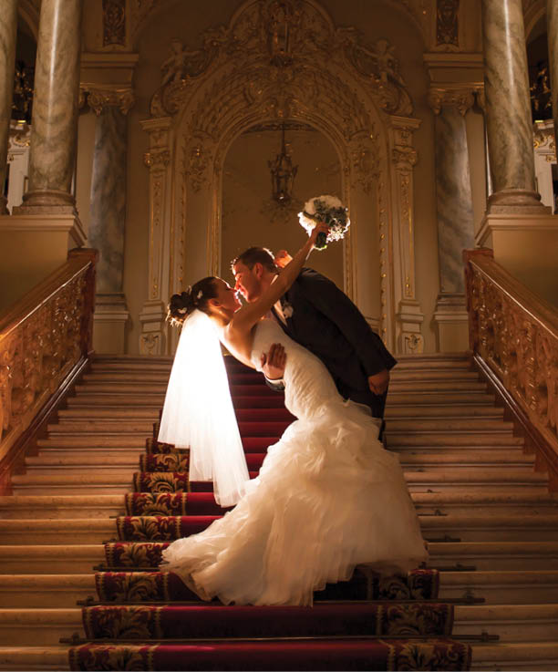 The groom is holding her bride and kissing in the church.