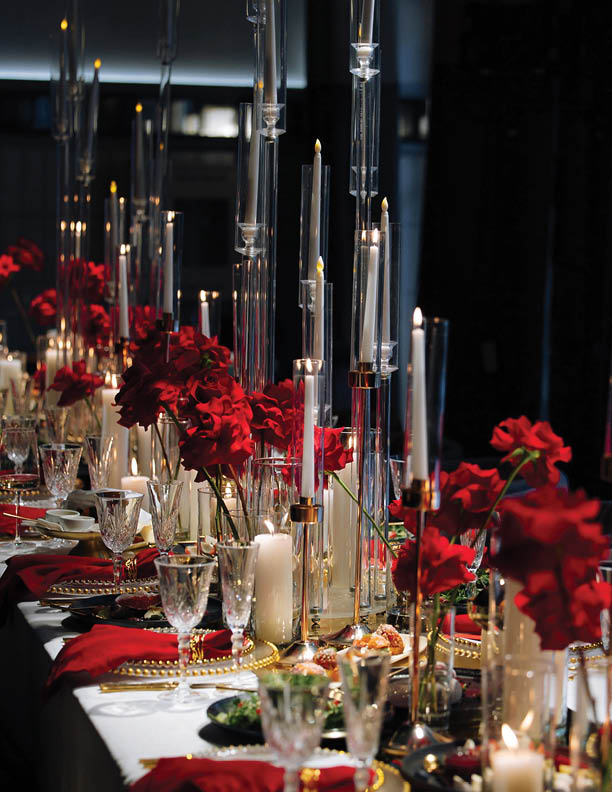 Luxurious table setting with red and gold decor, featuring elegant crystal glasses, candles, and floral arrangements. A sophisticated and festive atmosphere perfect for weddings, gala dinners, or roma