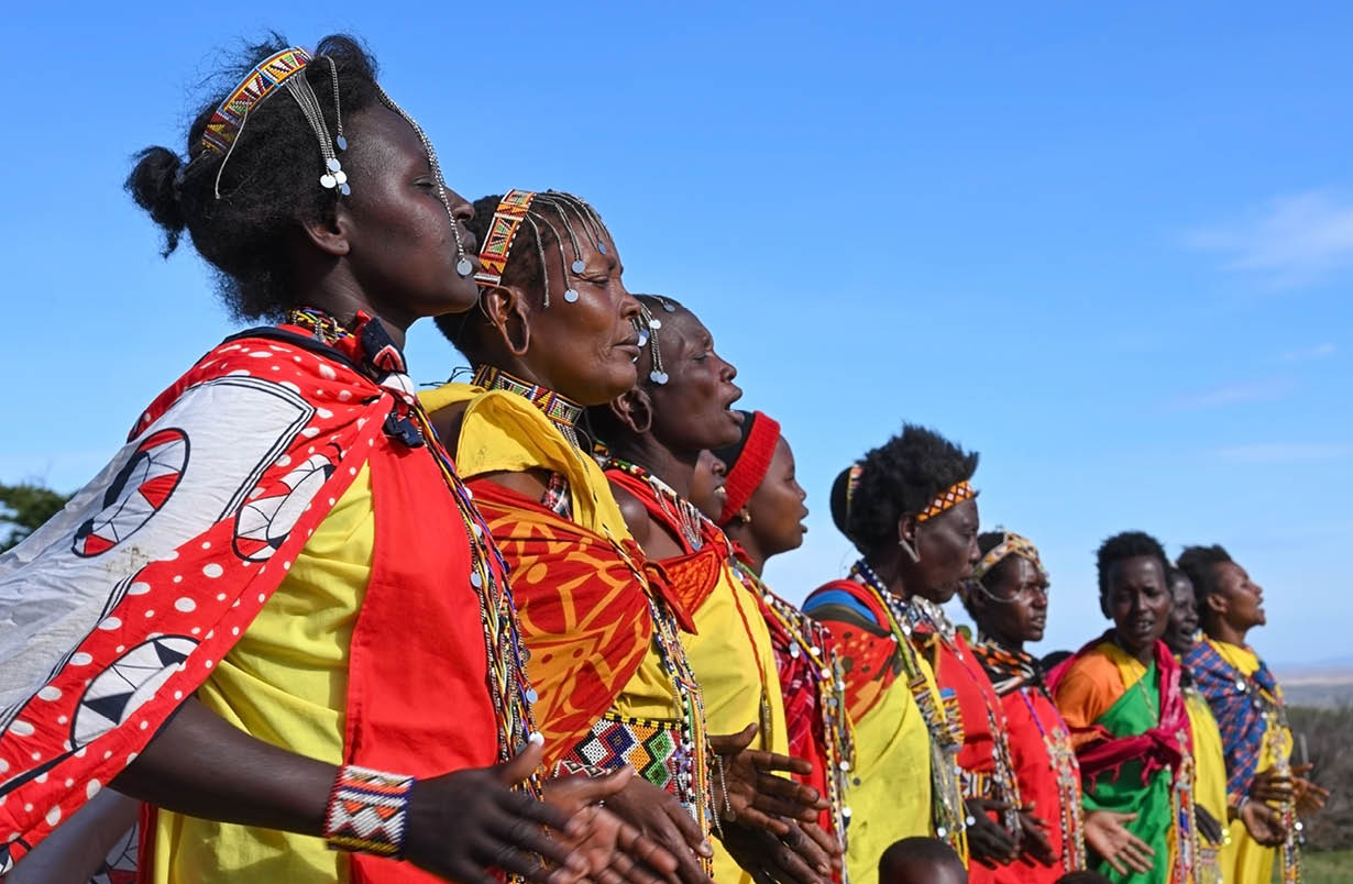 MAASAI MARA NATIONAL RESERVE, KENYA, AFRICA - NOVEMBER 11, 2022: People of Kenya. Group of Maasai women in traditional clothes and outfits singing a wedding song in a Maasai village in Kenya, Africa