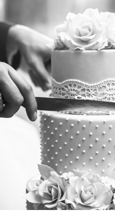A bride and a groom is cutting their wedding cake. beautiful cake. nicel light. wedding concept