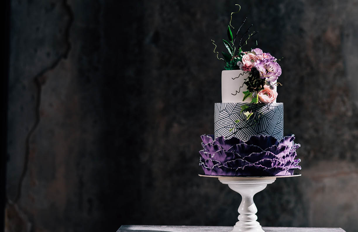 Closeup of white wedding cake with flowers on top. cake on the cake-shelf. white milk cream. cake decorated with pink and purple flowers
