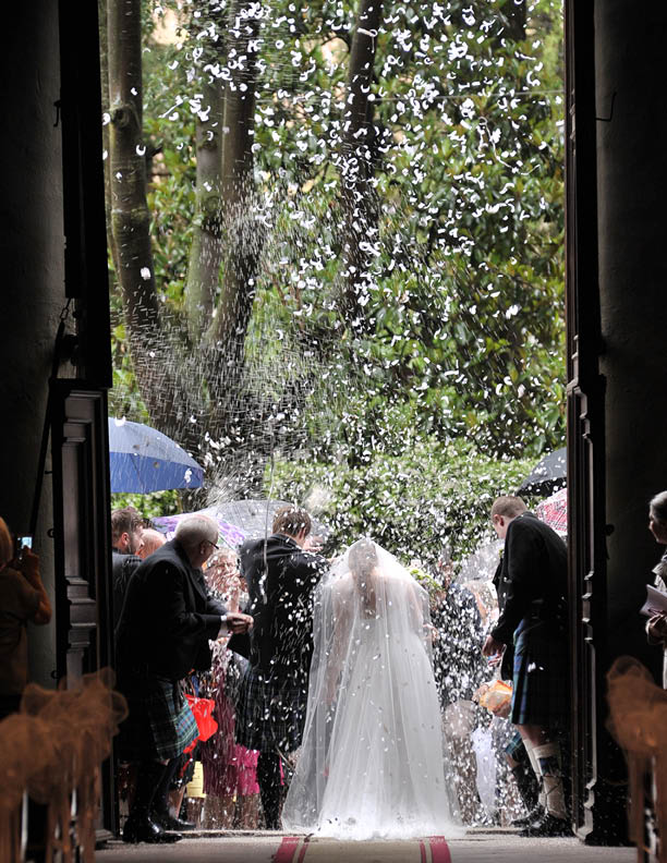 Groom in a traditional Scottish dress and bride in white, at the feast