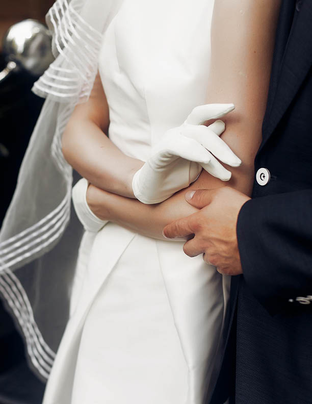 elegant gorgeous bride and stylish handsome groom holding hands close up, gentle touch. unusual luxury wedding in retro style. amazing romantic moment