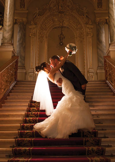 The groom is holding her bride and kissing in the church.