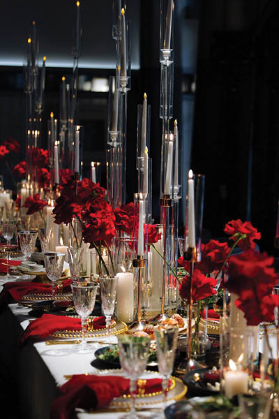 Luxurious table setting with red and gold decor, featuring elegant crystal glasses, candles, and floral arrangements. A sophisticated and festive atmosphere perfect for weddings, gala dinners, or roma