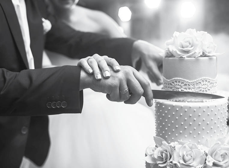 A bride and a groom is cutting their wedding cake. beautiful cake. nicel light. wedding concept