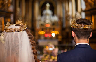 Fairytale couple, bride and groom in crowns during wedding ceremony in church