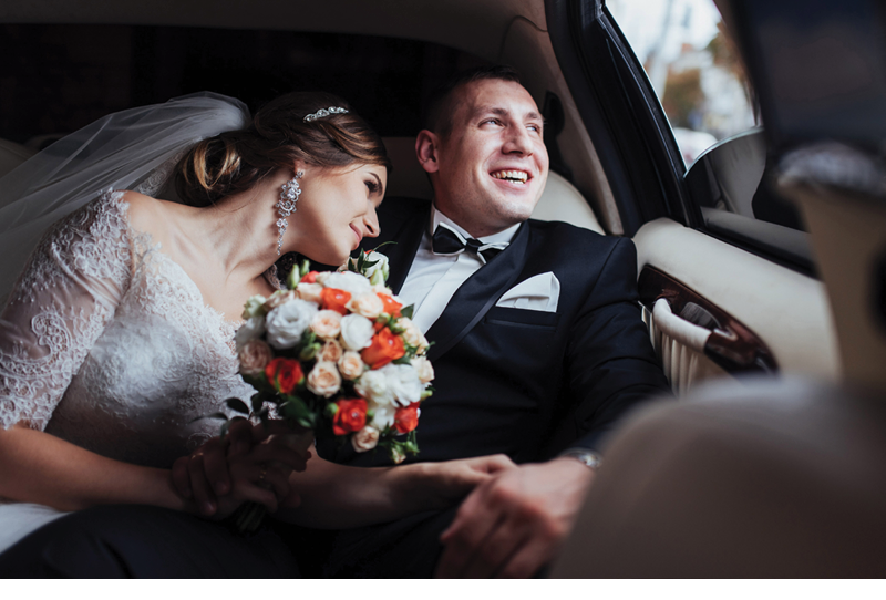 young couple in a car in wedding day