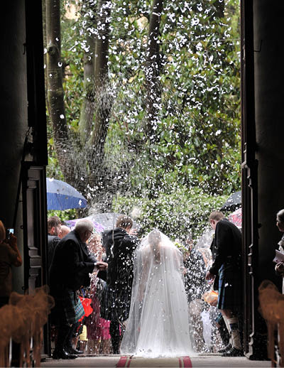 Groom in a traditional Scottish dress and bride in white, at the feast