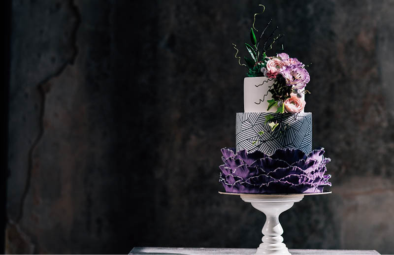 Closeup of white wedding cake with flowers on top. cake on the cake-shelf. white milk cream. cake decorated with pink and purple flowers